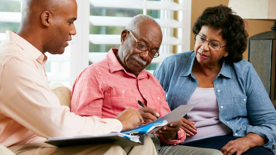 Financial Advisor Talking To Senior Couple At Home 177733410 5184x3456