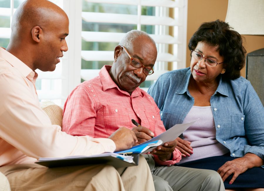 Financial Advisor Talking To Senior Couple At Home 177733410 5184x3456