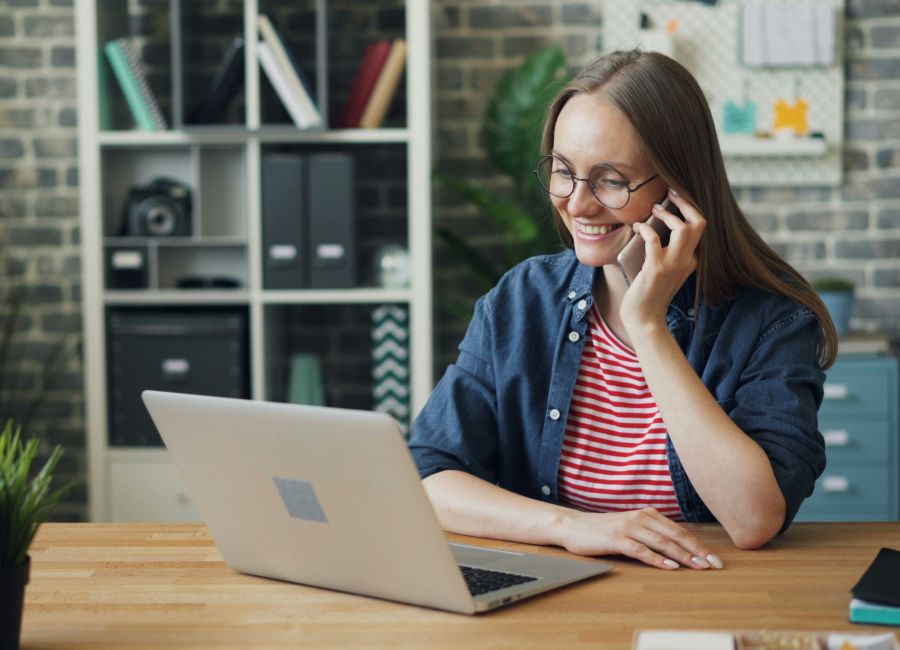 Woman on phone and laptop after Skip Tracing